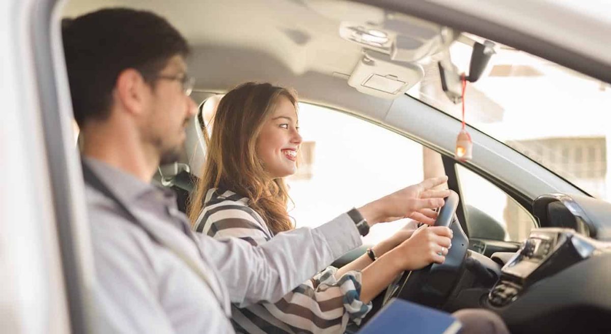 Young woman on a driving test with her instructor